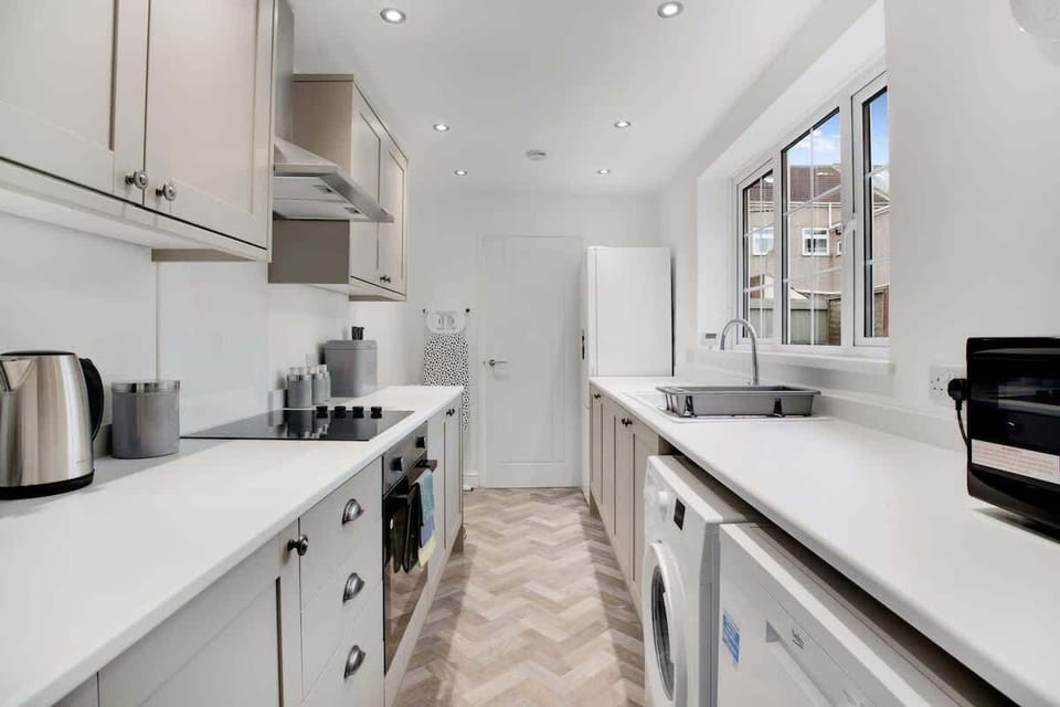 Kitchen equipped with all essentials, including a washer & dryer, oven, fridge and full cookware set.