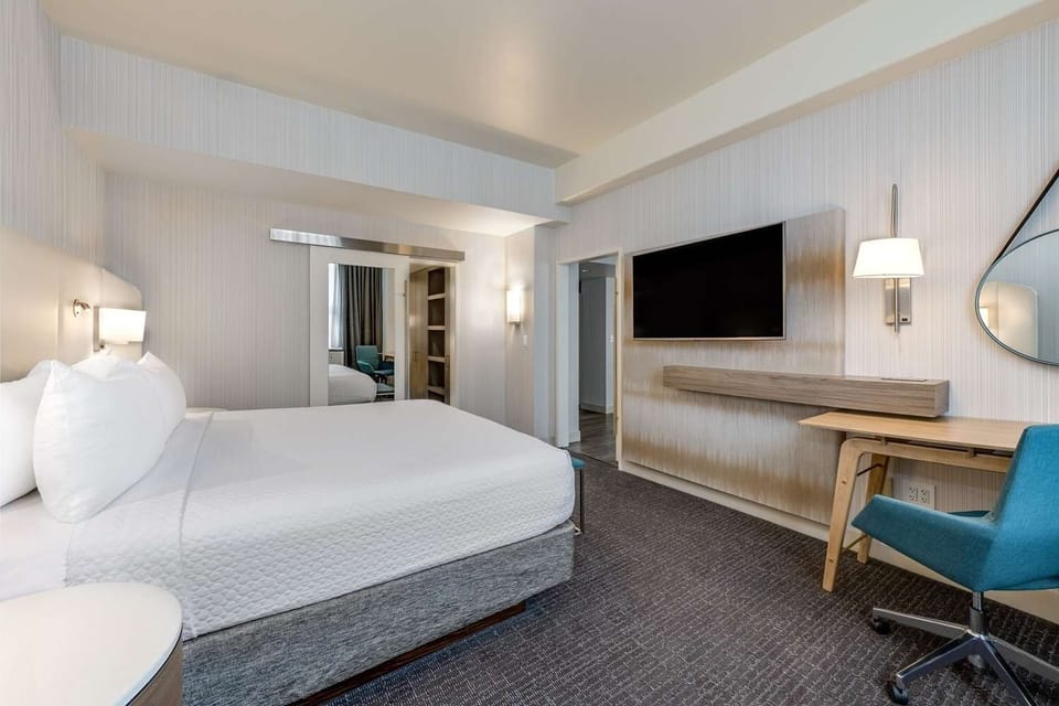 Unwind in a sleek suite with big TV and desk.
