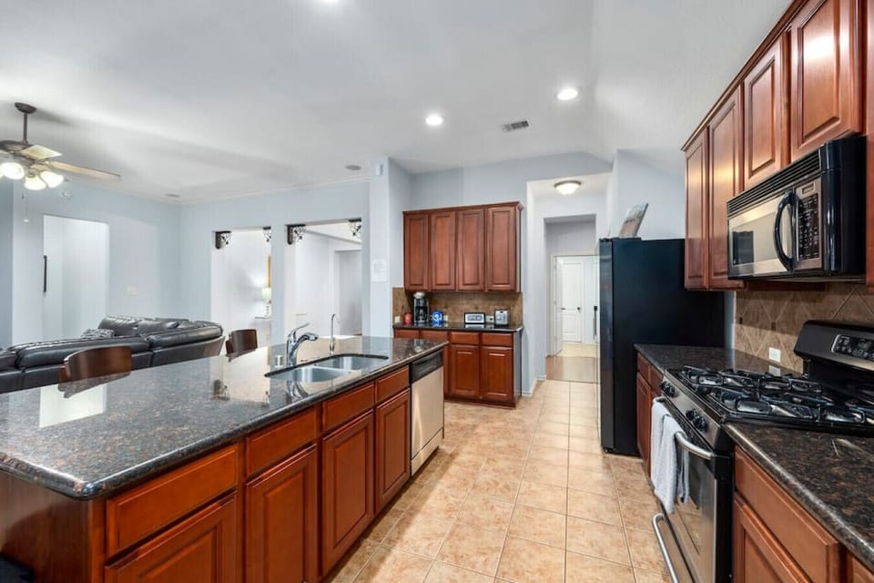 Kitchen with gas stove, coffee station, full-size fridge, and ample counter space for meal prep.
