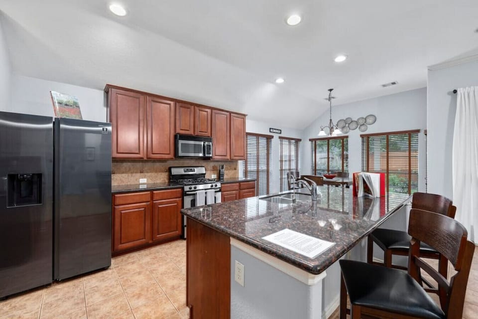 Fully equipped kitchen with granite countertops, stainless appliances, and large island for cooking and entertaining.