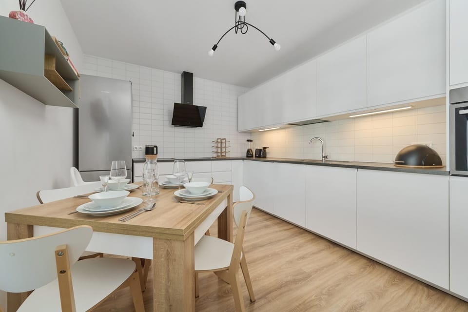 A dining area with a table set for four, seamlessly connected to the modern kitchen.

