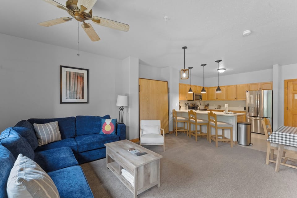 Living area offering cozy furnishings, a gas fireplace, ceiling fan, and Murphy bed.
