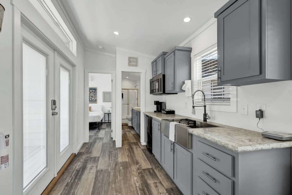 The cozy kitchenette features a compact ensemble: a mini fridge, microwave, and coffee pot, perfect for quick and convenient culinary moments.