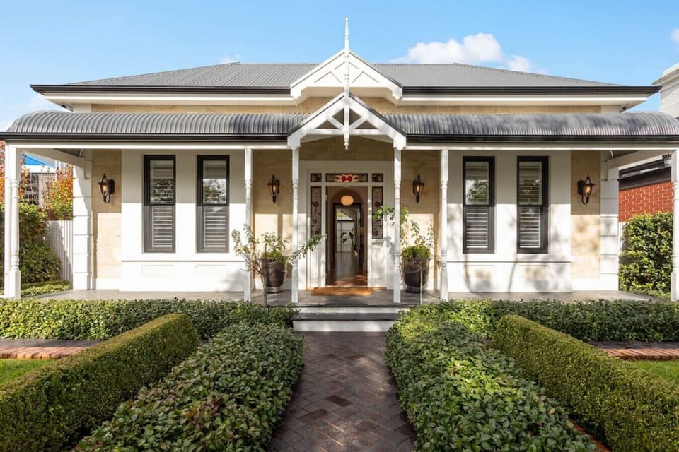 This beautifully maintained character home boasts a striking symmetrical façade, traditional gabled porch, and manicured hedges that lead you to a warm and welcoming entrance. A perfect blend of heritage charm and modern sophistication.