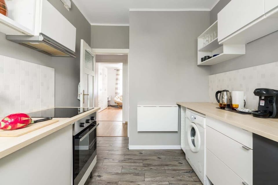 A functional kitchen layout with a long counter space, open shelving, and practical appliances for cooking needs.

