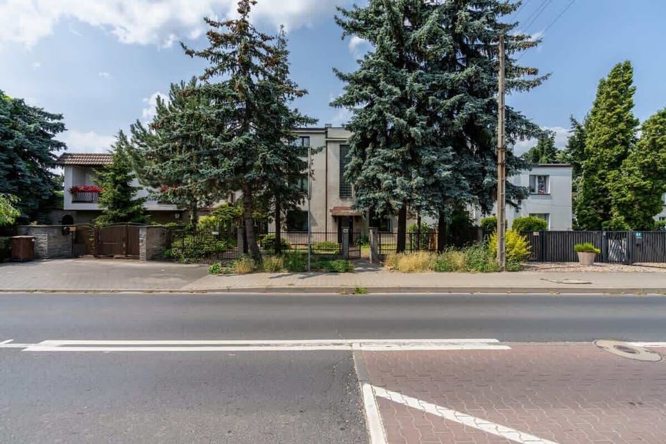 An exterior view of the building surrounded by greenery, highlighting a quiet and inviting neighborhood.

