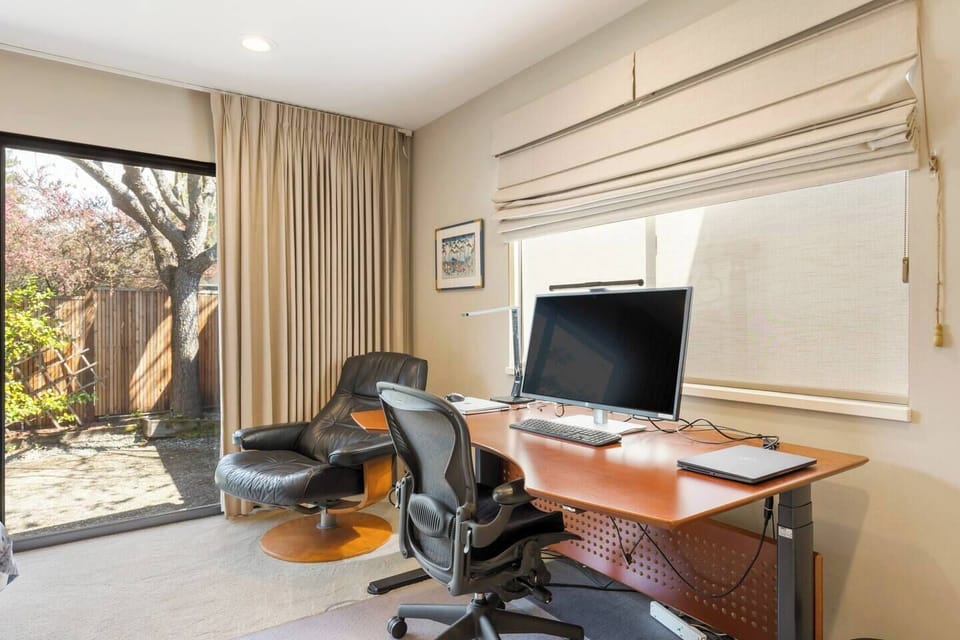 Large sit-stand desk with monitor, keyboard, mouse, and printer