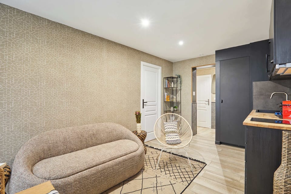 Salon avec canapé, cuisine ouverte et espace repas