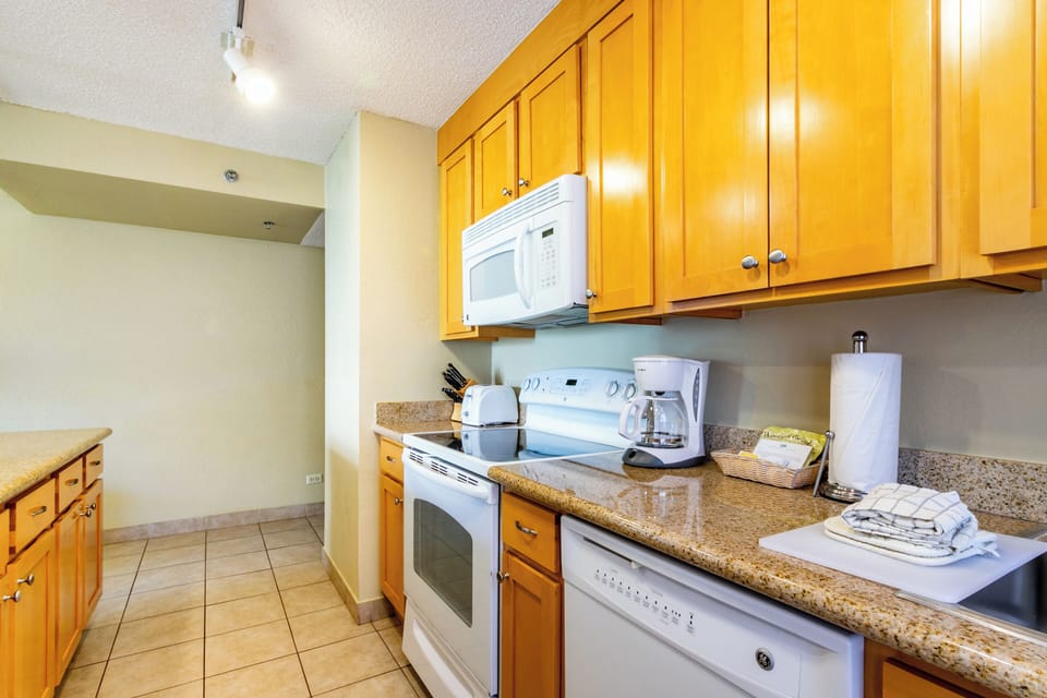 Your fully equipped kitchen has everything you need—sleek granite counters, modern appliances, and warm wood cabinetry create a welcoming space where you can brew morning coffee or prepare a home-cooked meal.
