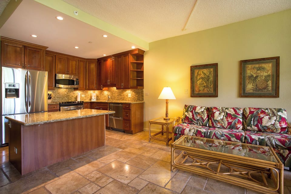 Unwind in your open-concept living space where rich wood cabinetry, granite countertops, and tropical-inspired décor create a warm island retreat for your vacation.