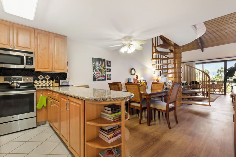 Your open-concept living space features a modern kitchen, warm wood accents, and a striking spiral staircase that leads to your private upstairs retreat.