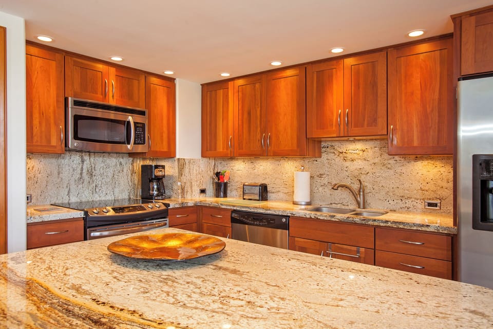 Your gourmet kitchen awaits with granite countertops, rich wood cabinetry, and modern stainless appliances—everything you need to prepare fresh meals during your stay.