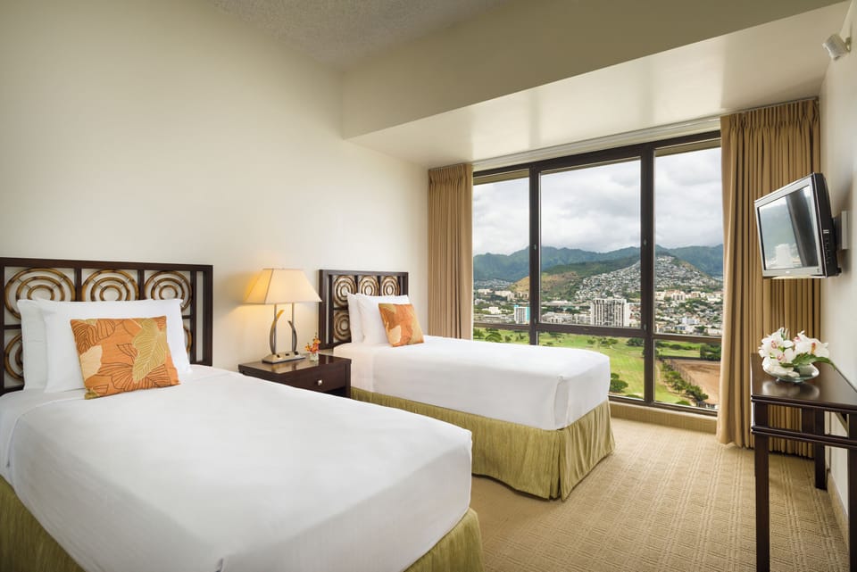 Wake up to sweeping mountain and cityscape views from your comfortable twin beds, where natural light floods the serene space through floor-to-ceiling windows.