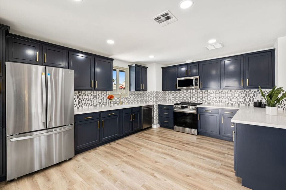 Modern kitchen w/ stainless appliances, dark cabinetry & generous prep space for easy meals.