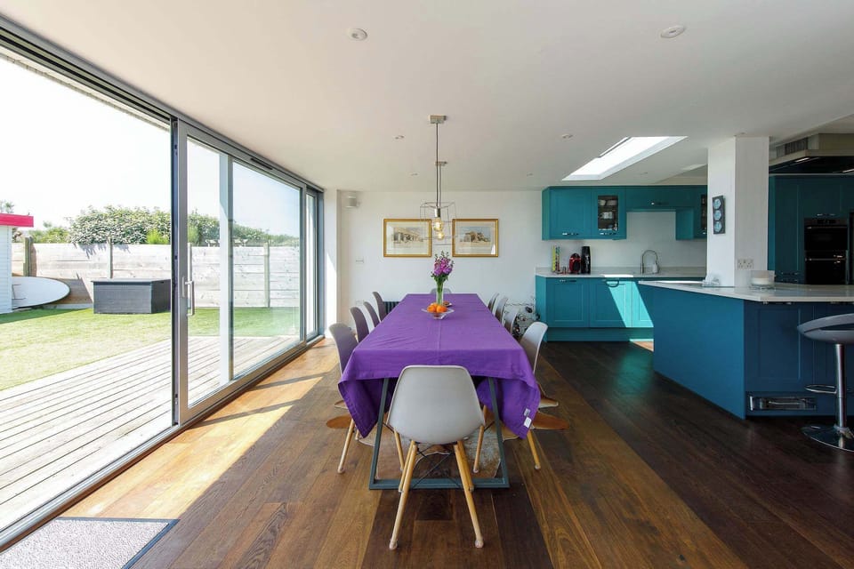 The main dining area sits between the kitchen and the patio. Open up the sliding doors on warmer days to enjoy the sea breeze while you eat.