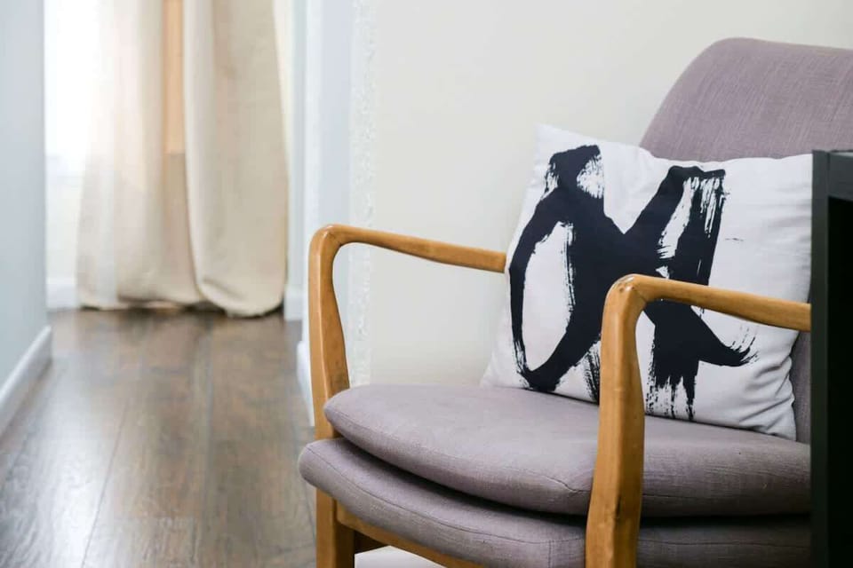 Comfy bedroom chair by the window, a quiet spot to sit & unwind