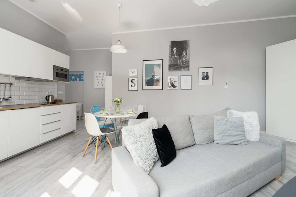 Contemporary living space with a large gray sofa, wall art, and a flat-screen TV for relaxed evenings.

