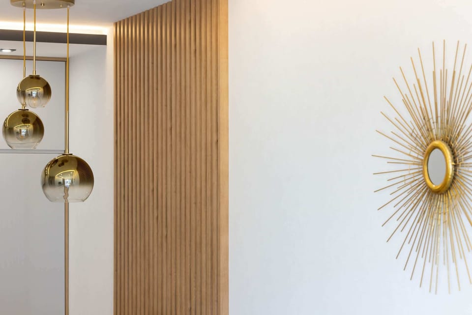 Decorative touches in the apartment, including gold lighting fixtures and a modern sunburst wall piece.

