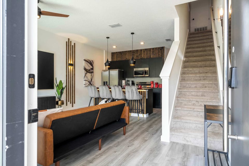 Stylish open-concept living-sleek kitchen with island seating for four, pendant lighting, and a comfy lounge welcome you in.