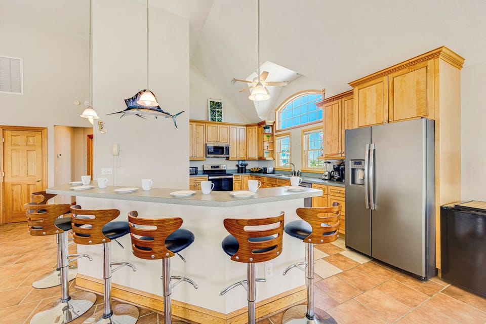 A chef's oasis featuring a sleek breakfast bar and premium stainless steel appliances.