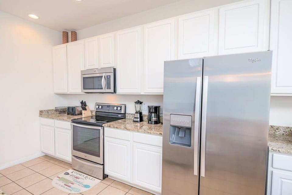 A fully equipped kitchen with updated appliances and a breakfast bar.