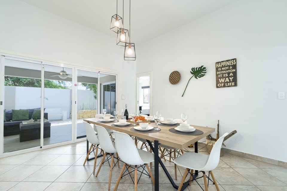 Marvelous dinning area of the 3BR house in Noord Aruba - Beautiful outdoor sitting facing dinning area of the villa - Elite 8 persons dinning - Stunningly located large window with outside views - Majestic space with beautiful paintings and chandelier