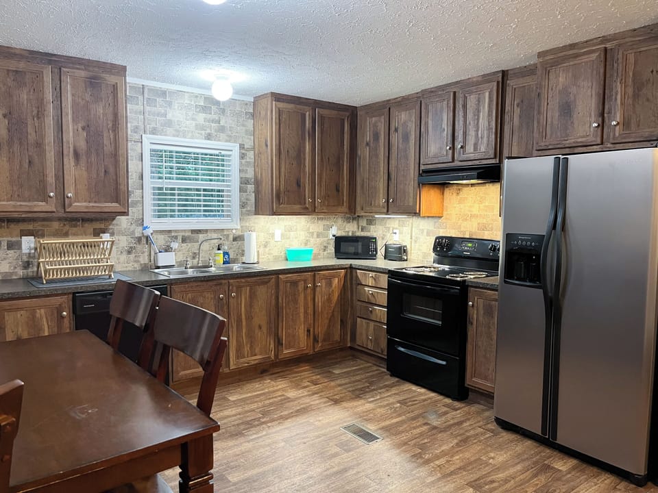 Fully equipped kitchen w/ dishwasher, stove, fridge, microwave, & cooking tools