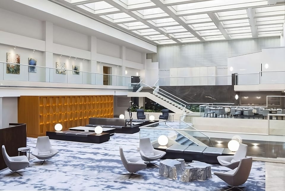 Step into a soaring atrium lobby filled with daylight.