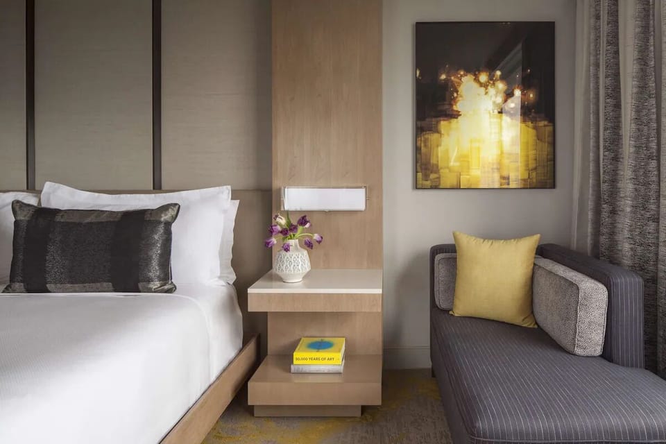 Sink into crisp linens beside a cozy lounge chair.