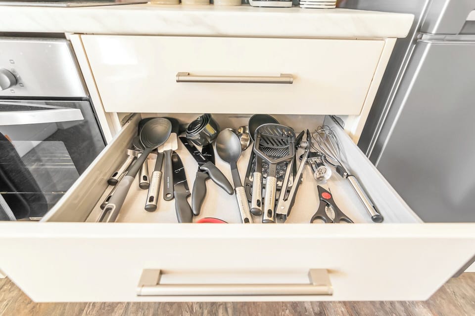The kitchen utensils are neatly organized and readily accessible, housed in drawers and utensil holders strategically placed for maximum convenience
