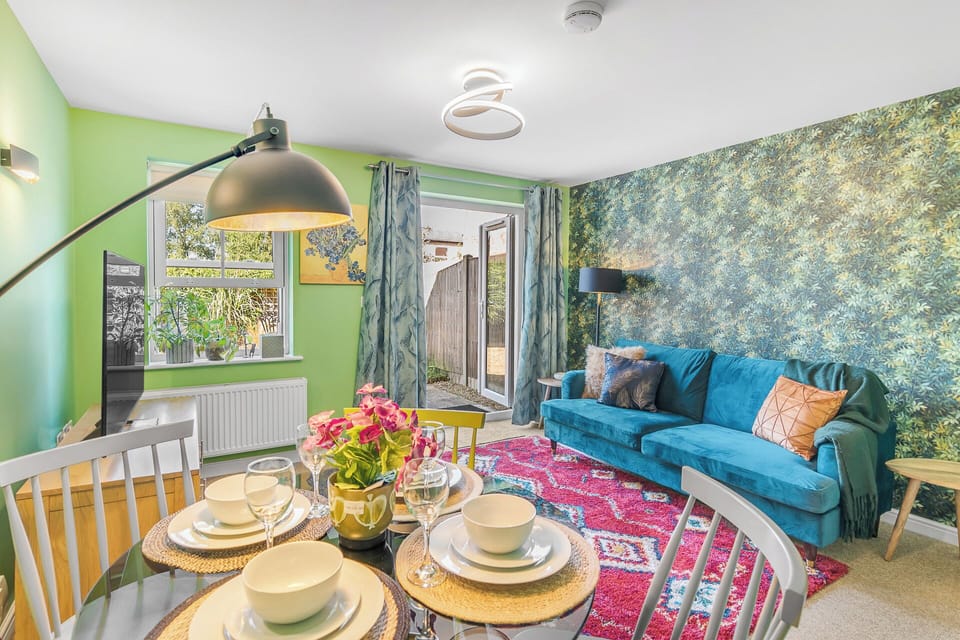 As you step into the dining room, your eyes are immediately drawn to the vibrant centerpiece - a truly captivating and colorful dining table that exudes an air of lively elegance. 