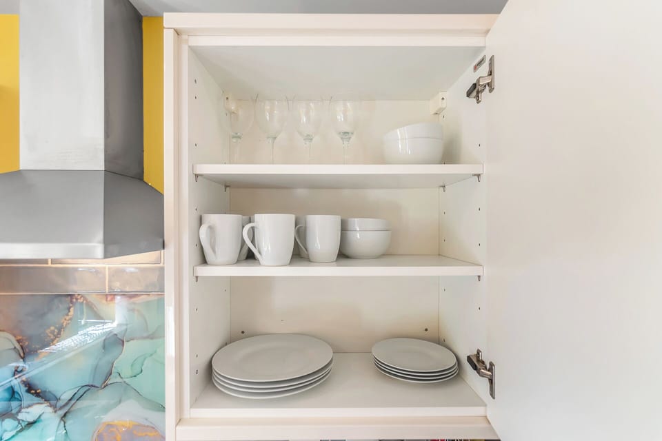 Drinking and wine glasses, plates and coffee cups are conveniently stocked and placed in an easily accessible location.