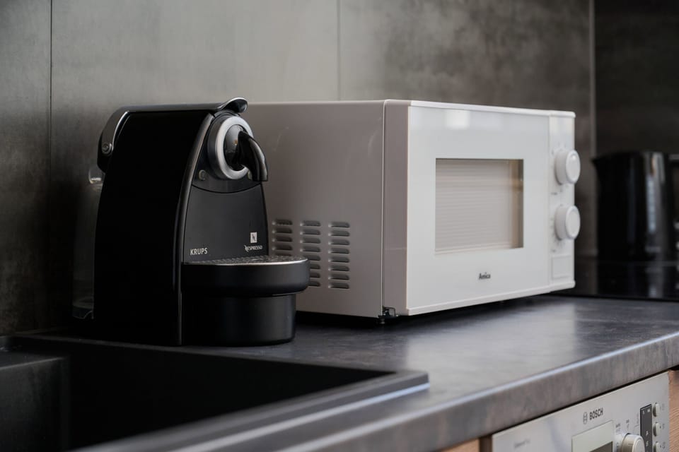 Close-up of a coffee machine and microwave, offering convenience for preparing meals and drinks.

