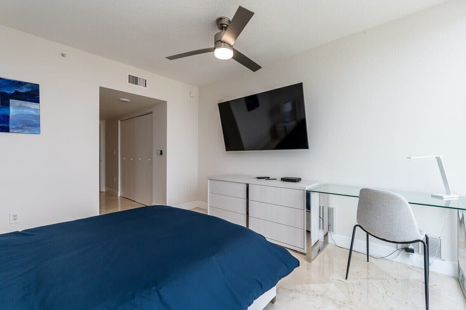 Second bedroom - queen bed - 55" smart TV - workspace - city views.