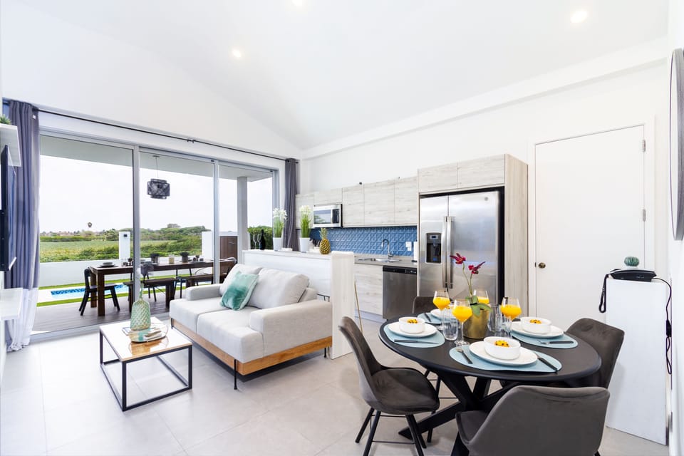 Step into this bright, open-concept space where the living, dining, and kitchen areas blend seamlessly, offering expansive green views beyond your sliding doors.