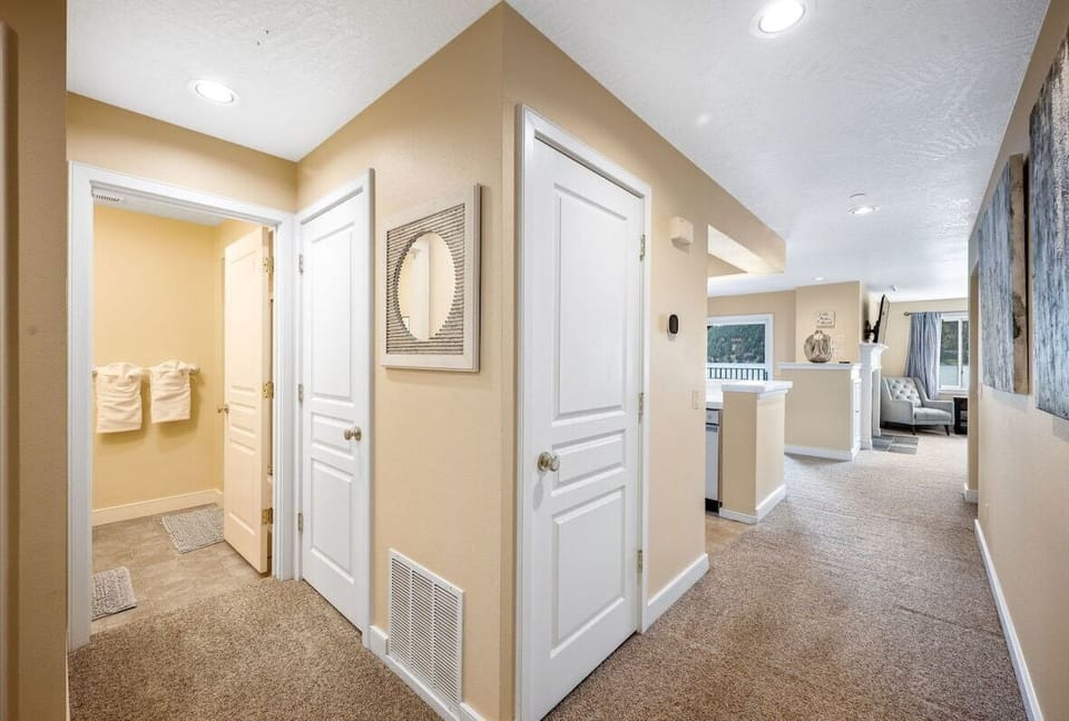 Your spacious hallway connects every room, with soft carpeting underfoot and warm lighting creating a welcoming atmosphere throughout your stay.