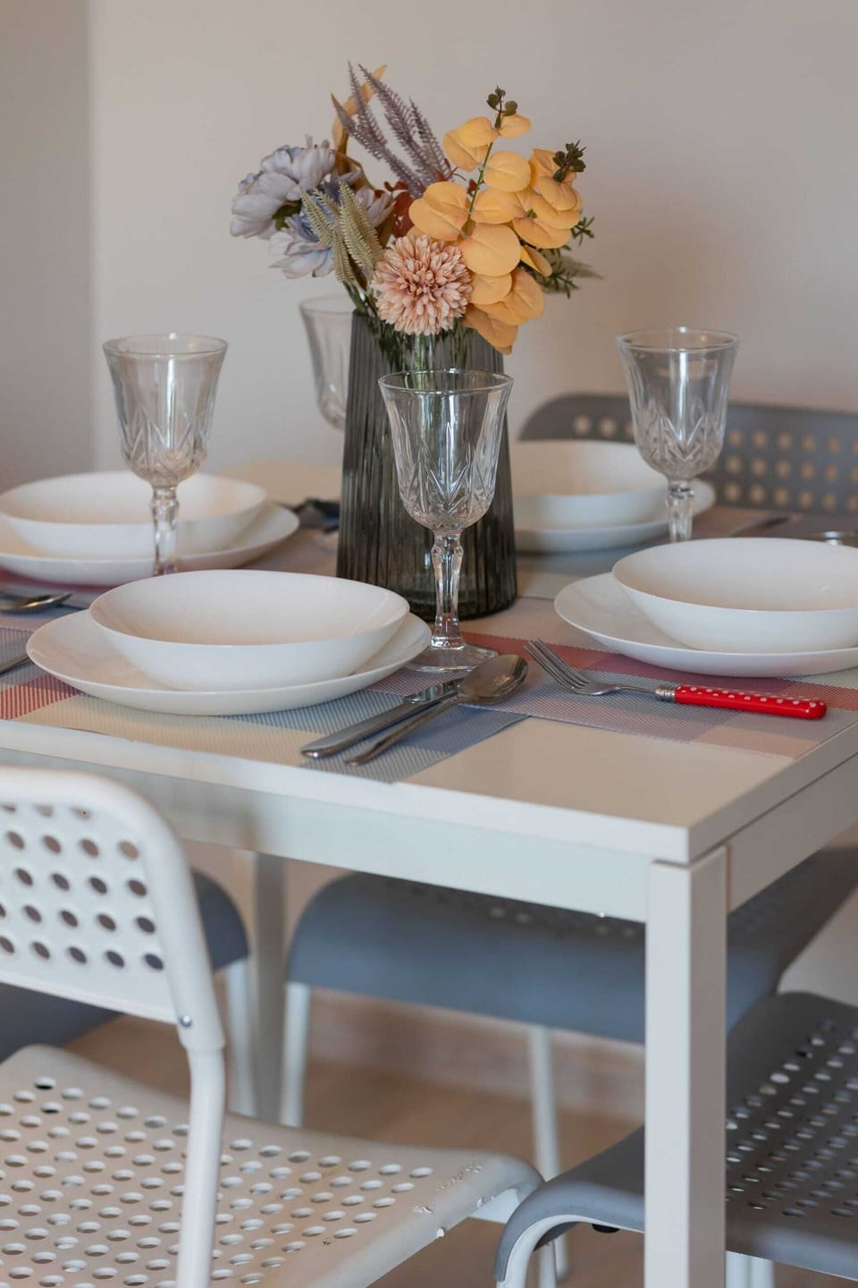 Dining area with a small table, stylish chairs, and a vibrant floral centerpiece for a welcoming touch.
