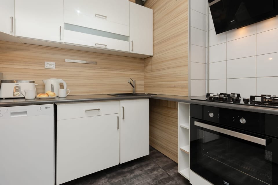 Fully equipped kitchen with white cabinets, wooden accents, and modern appliances.

