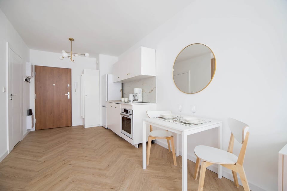Dining area with a round table and chairs, complemented by natural light and elegant decor.

