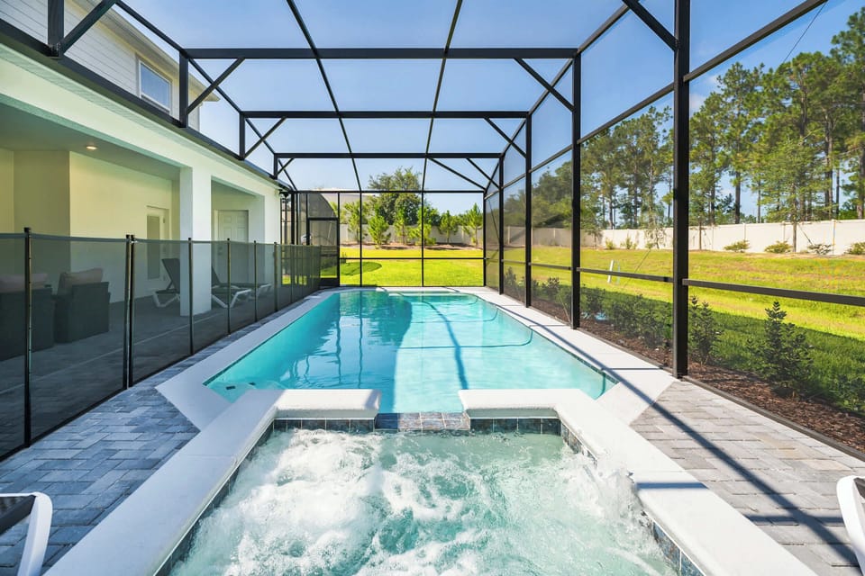 Relax in your private screened-in pool and hot tub oasis, perfect for unwinding and enjoying the serene views.