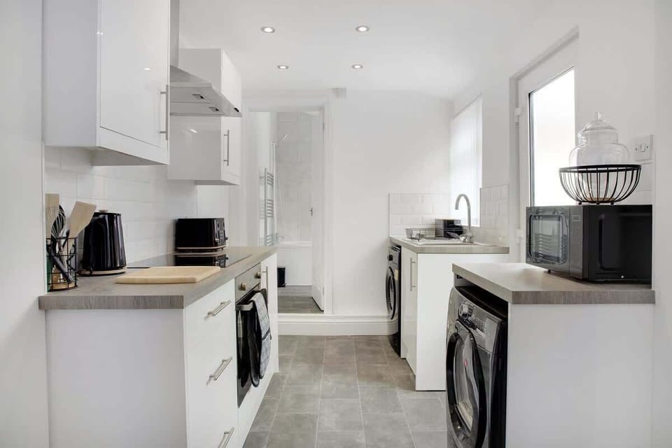 Kitchen equipped with all essentials, including a washer & dryer, oven, fridge and full cookware set.