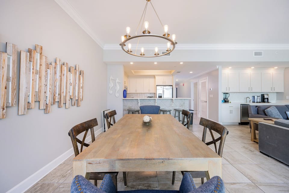 Gather at the large wood dining table under the chandelier for family meals or a fun game night