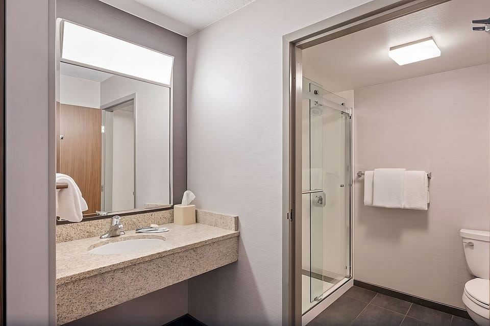 Refresh easily in a spotless bathroom with glass-enclosed shower.