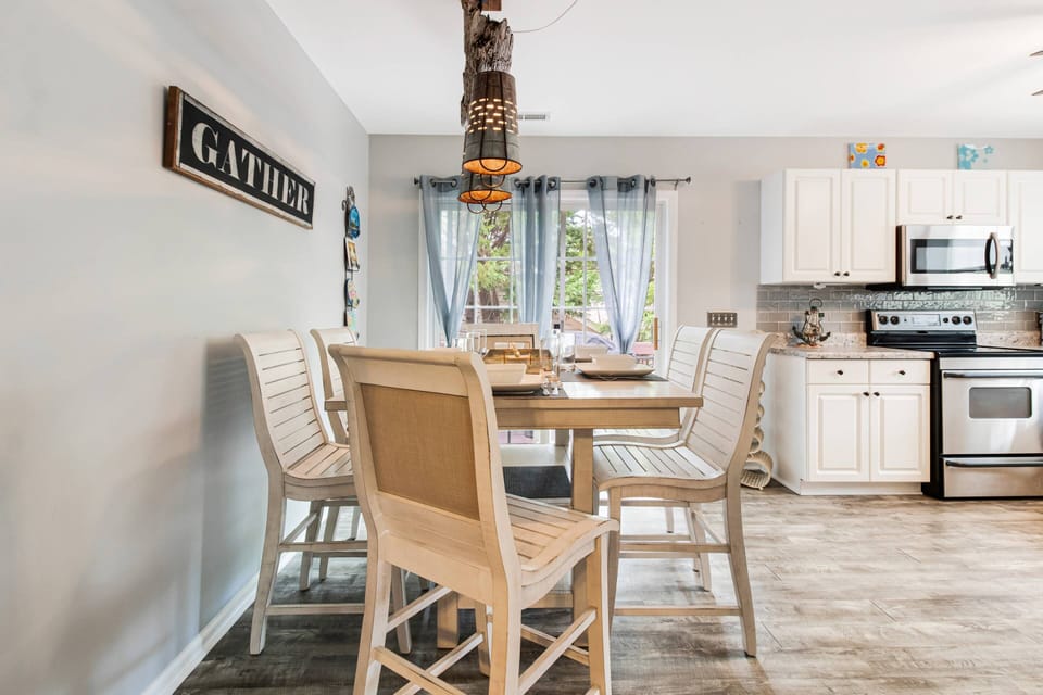 "Gather" for Memorable Meals in this Dining Area, Adjacent to the Kitchen. The Sliding Doors lead to a Deck with a Grill & Seating.