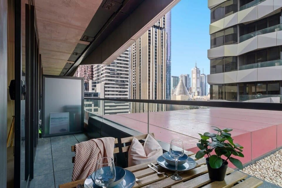 A balcony with a setting & city views.