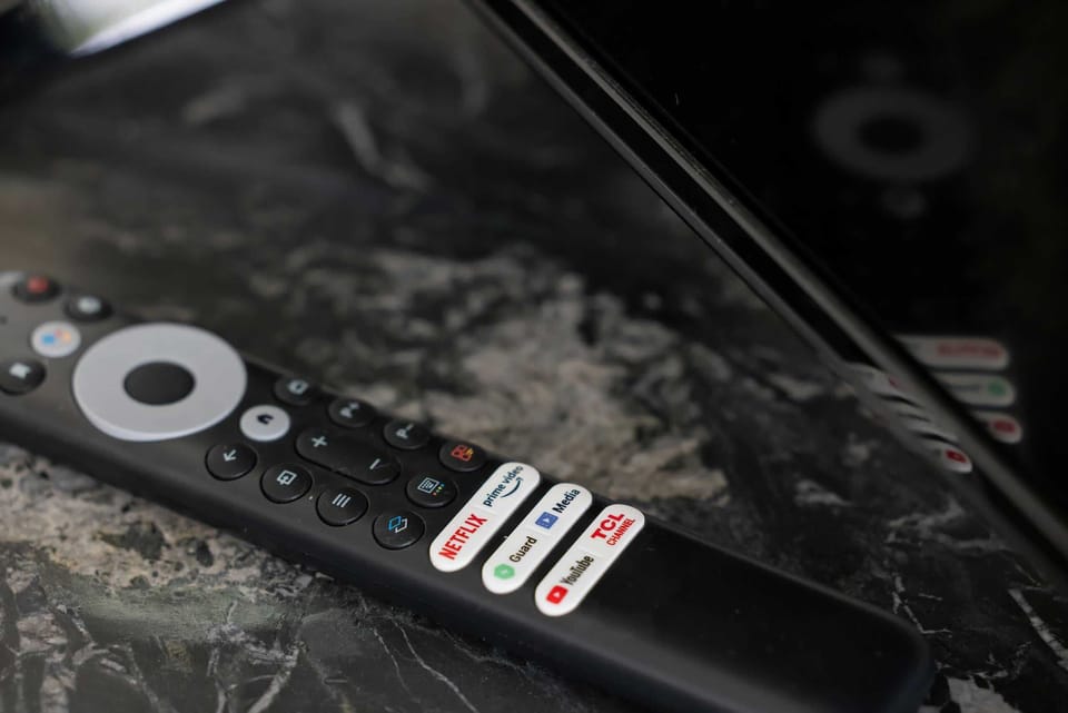 A close-up of a TV remote placed on a marble table, emphasizing attention to detail.


