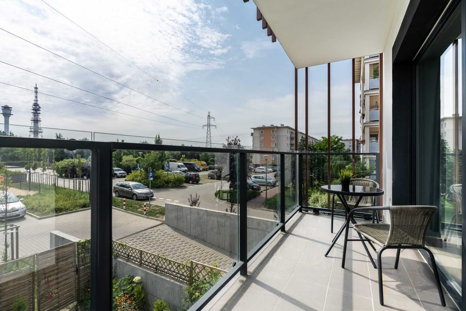 Balcony with a cozy seating area and a view of the surrounding urban landscape.
