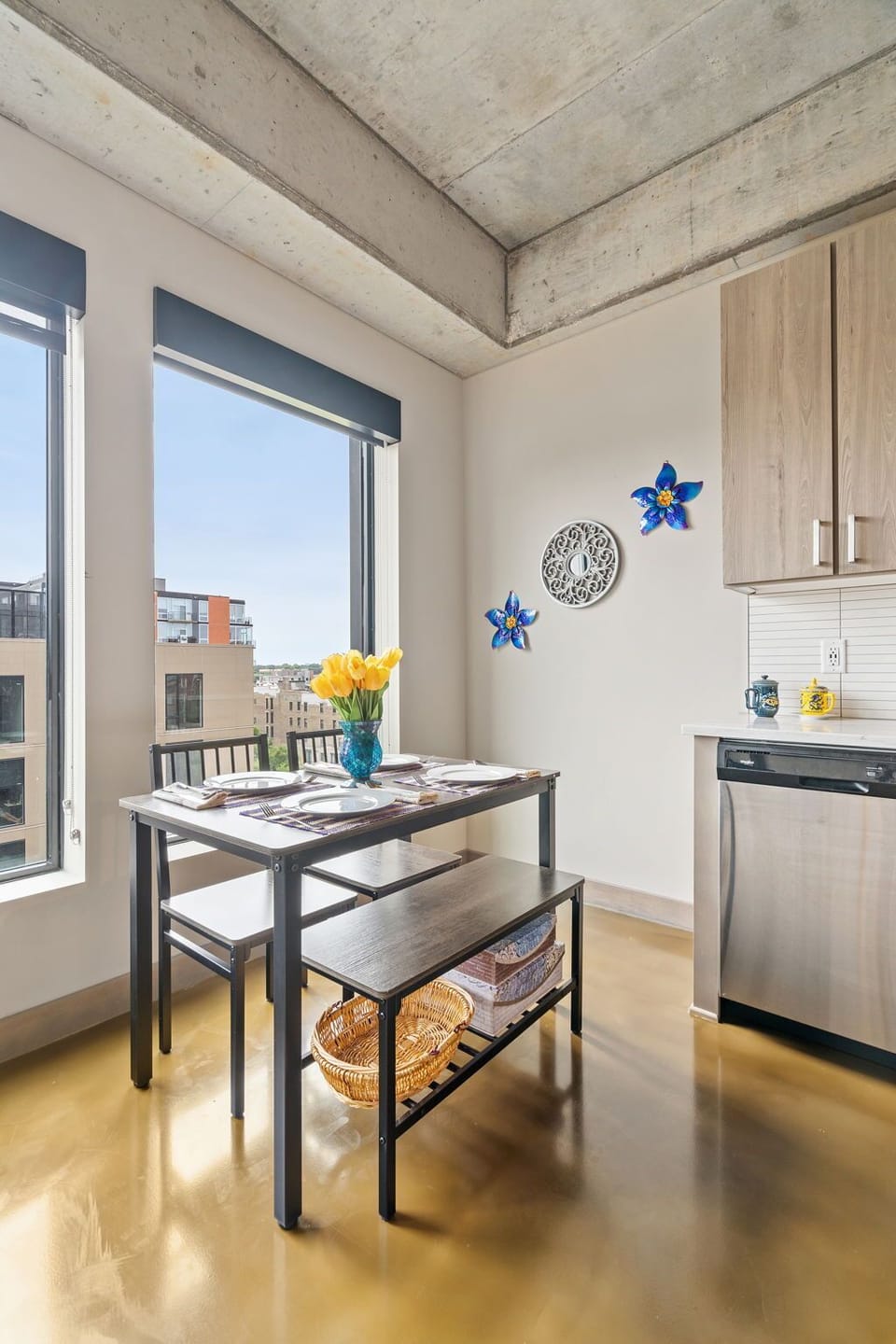 Start your morning with coffee at this bright dining table, where exposed concrete meets warm wood and natural light fills the space.