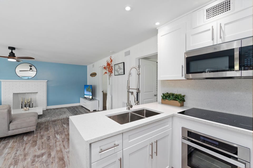 Waterfall quartz countertops, stainless steel appliances, induction stovetop.