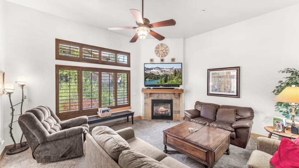 - Relax in the cozy living room with plush seating and a warm fireplace  
- Enjoy movie nights on the flat screen with natural light streaming in  
- Large windows with wood accents create a bright and inviting space